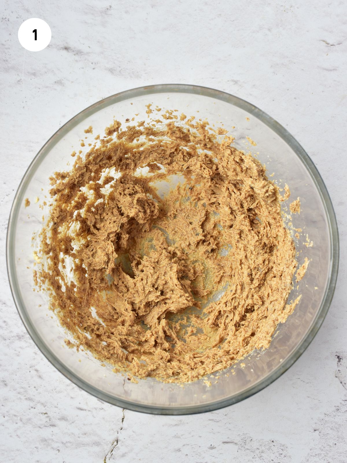 butter and sugars combined in a clear mixing bowl