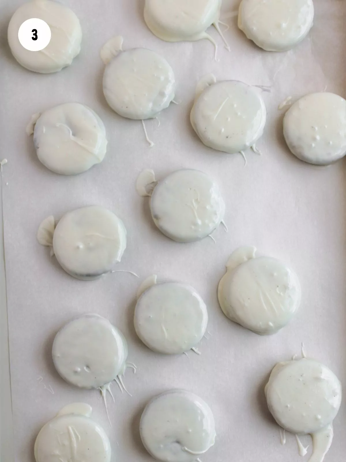 white chocolate dipped oreos on parchment paper