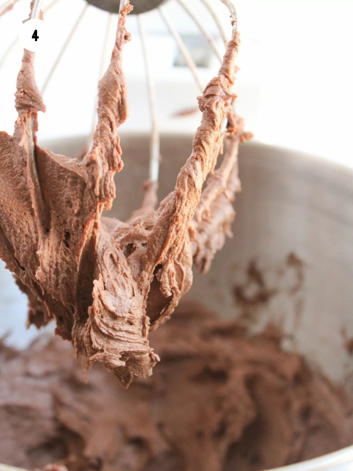 chocolate frosting on a whisk attachment