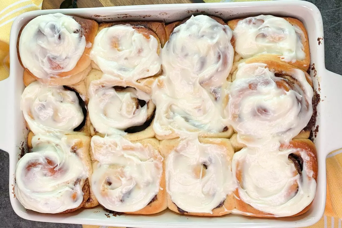 bread machine cinnamon rolls baked and frosted in casserole dish.