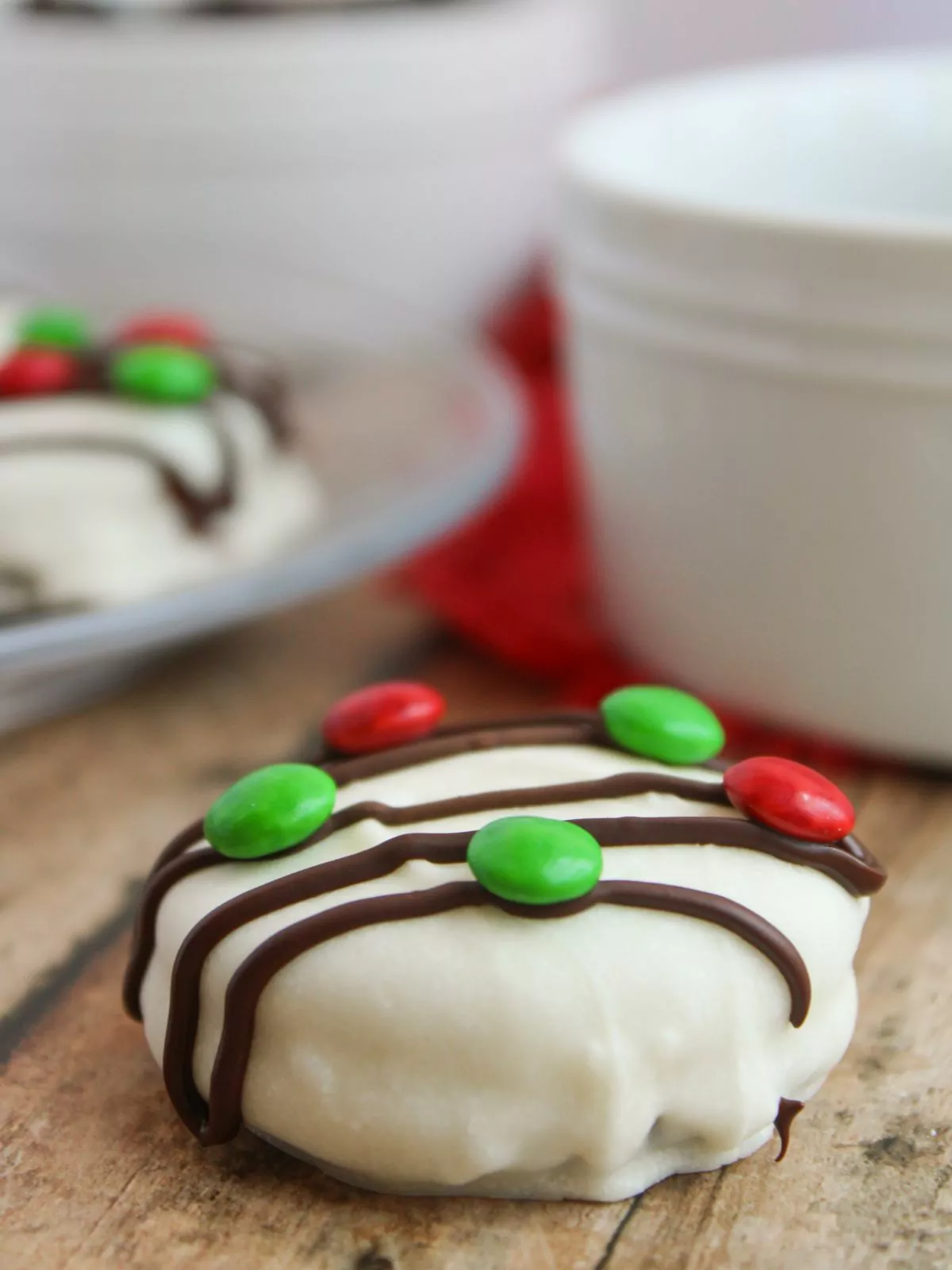 red and green Mini M&M's added to chocolate drizzle white chocolate oreos