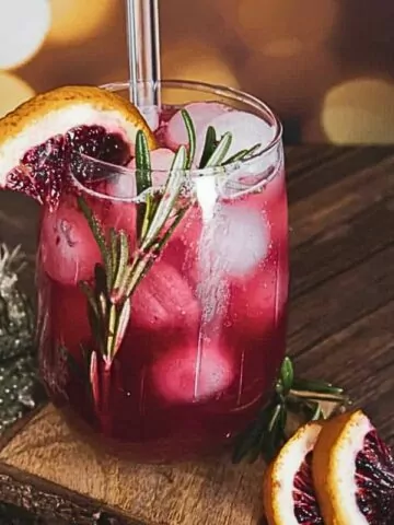 cranberry drink with sprigs of rosemary and blood orange slices.