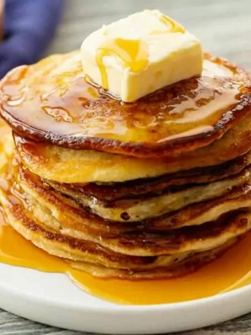 stack of pancakes on plate with butter and syrup. MSN.