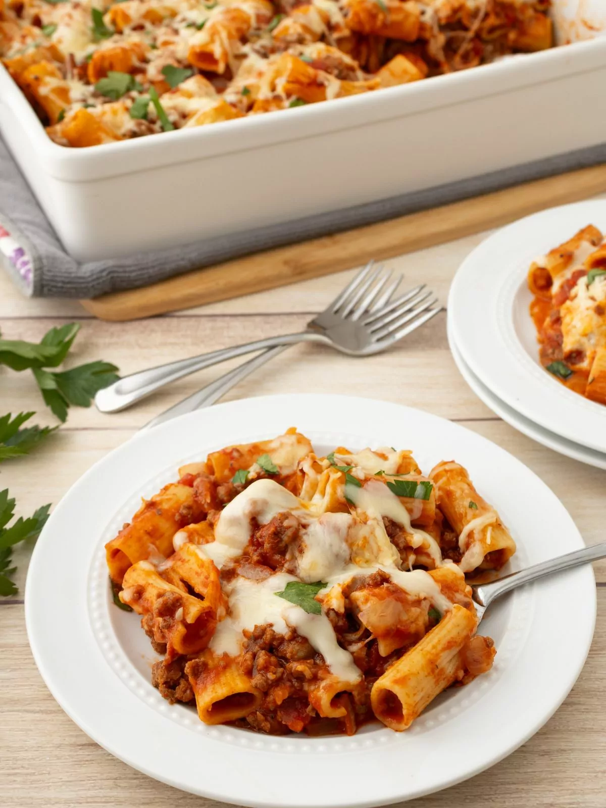 Baked Rigatoni served on a white plate with the baking dish in the background