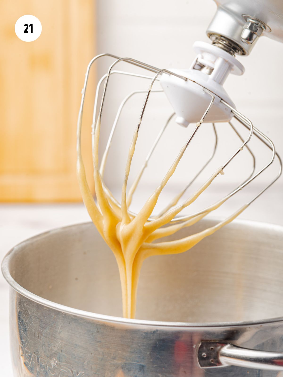 brown butter maple syrup icing dripping from whisk attachment on a mixer. 