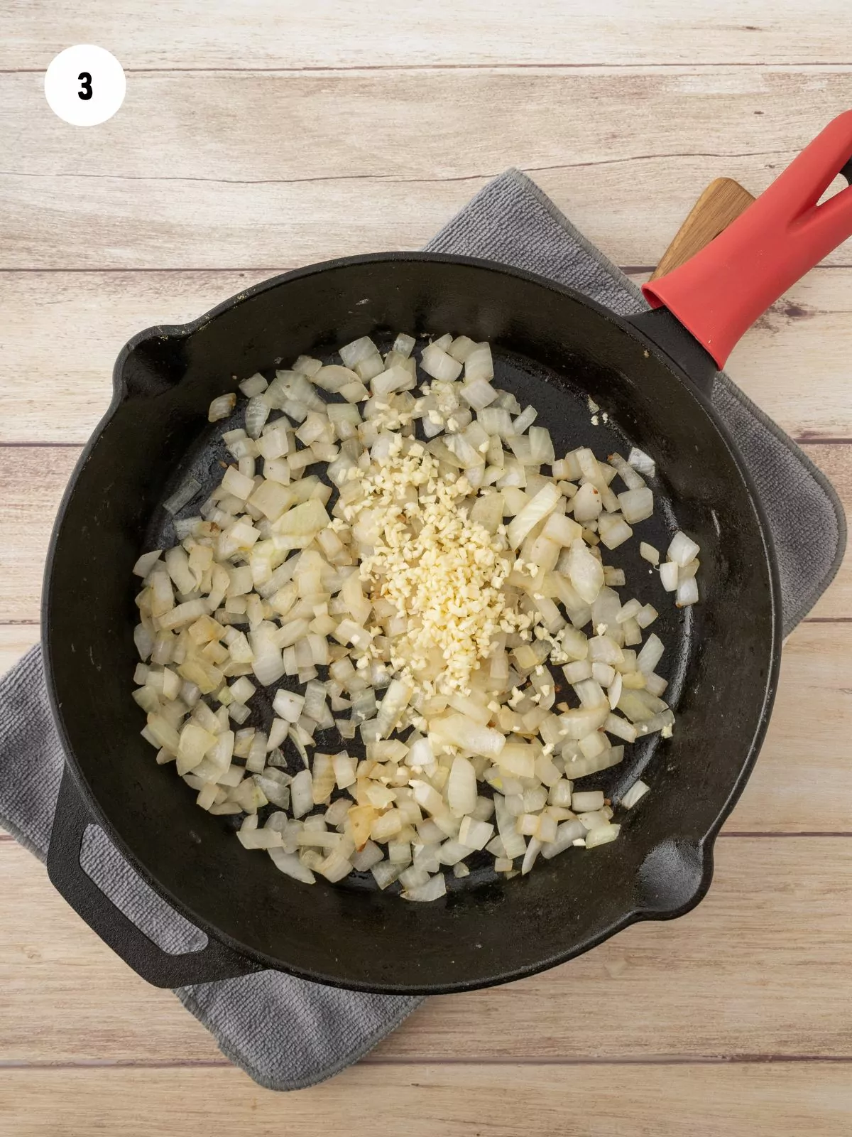 minced garlic added to the diced onions in an iron skillet