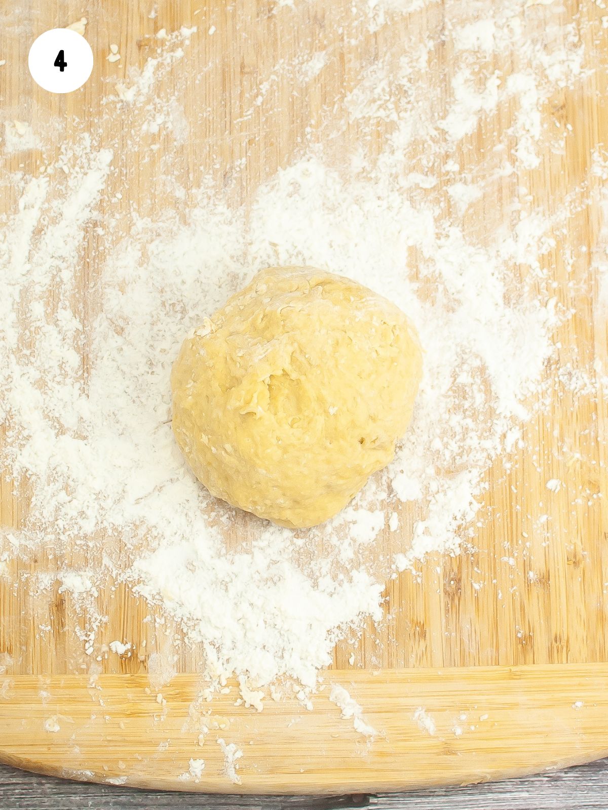 ball of dough on a floured wood cutting board