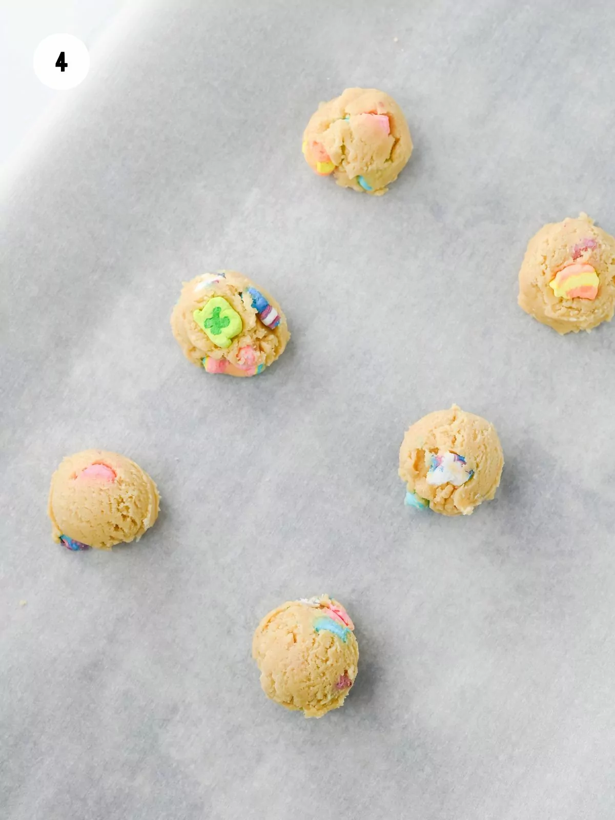 scoops of cookie dough on a parchment paper lined baking sheet