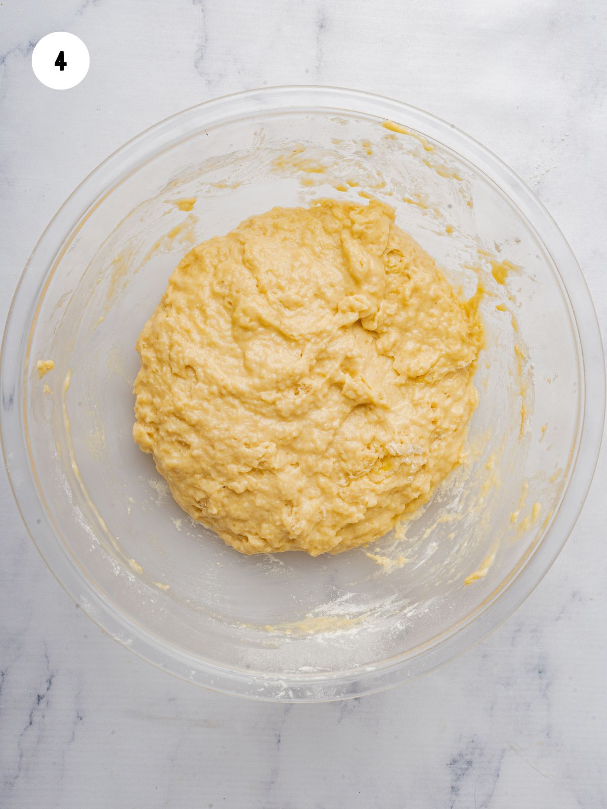 shaggy dough formed in a clear mixing bowl