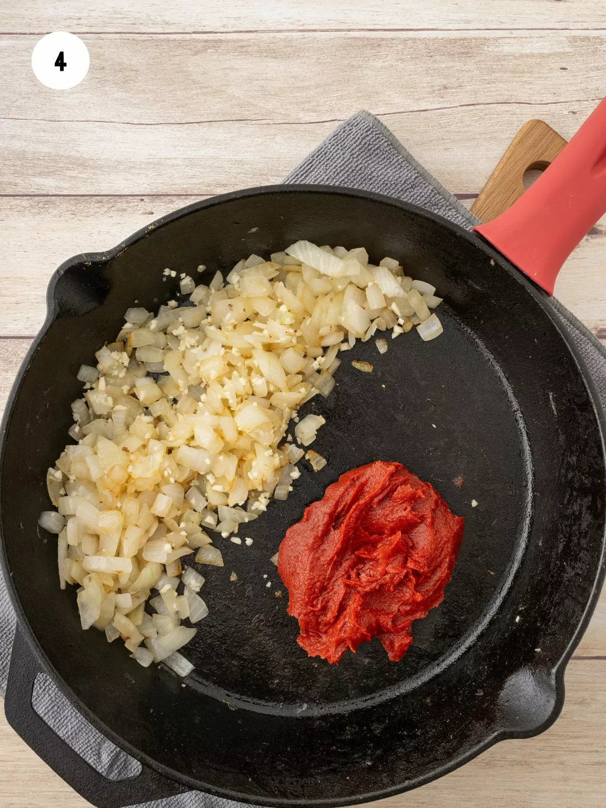 cooked onion and garlic pushed to the side of the pan and tomato sauce added to the other side.