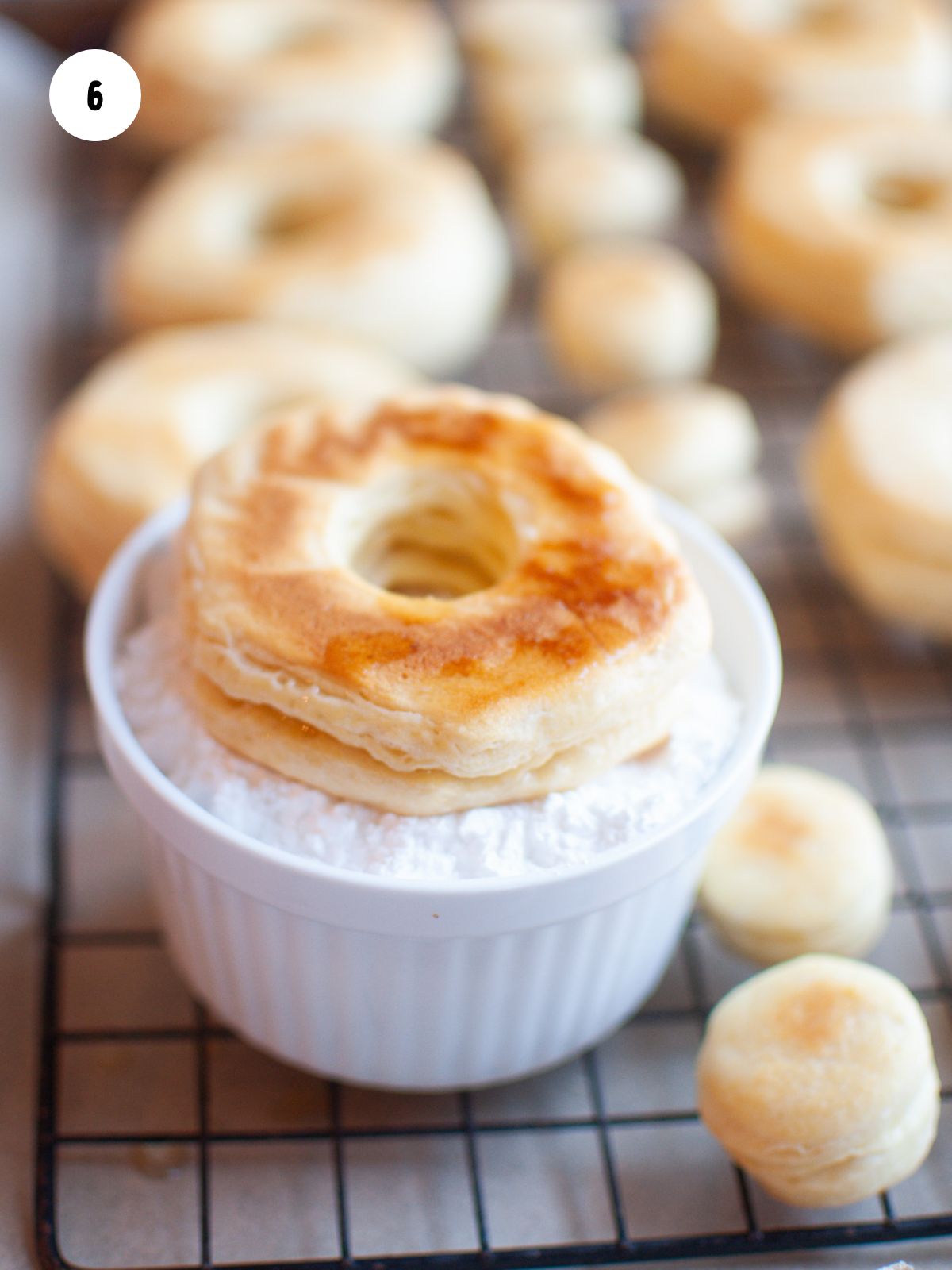 donut dipped in ramekin of powdered sugar
