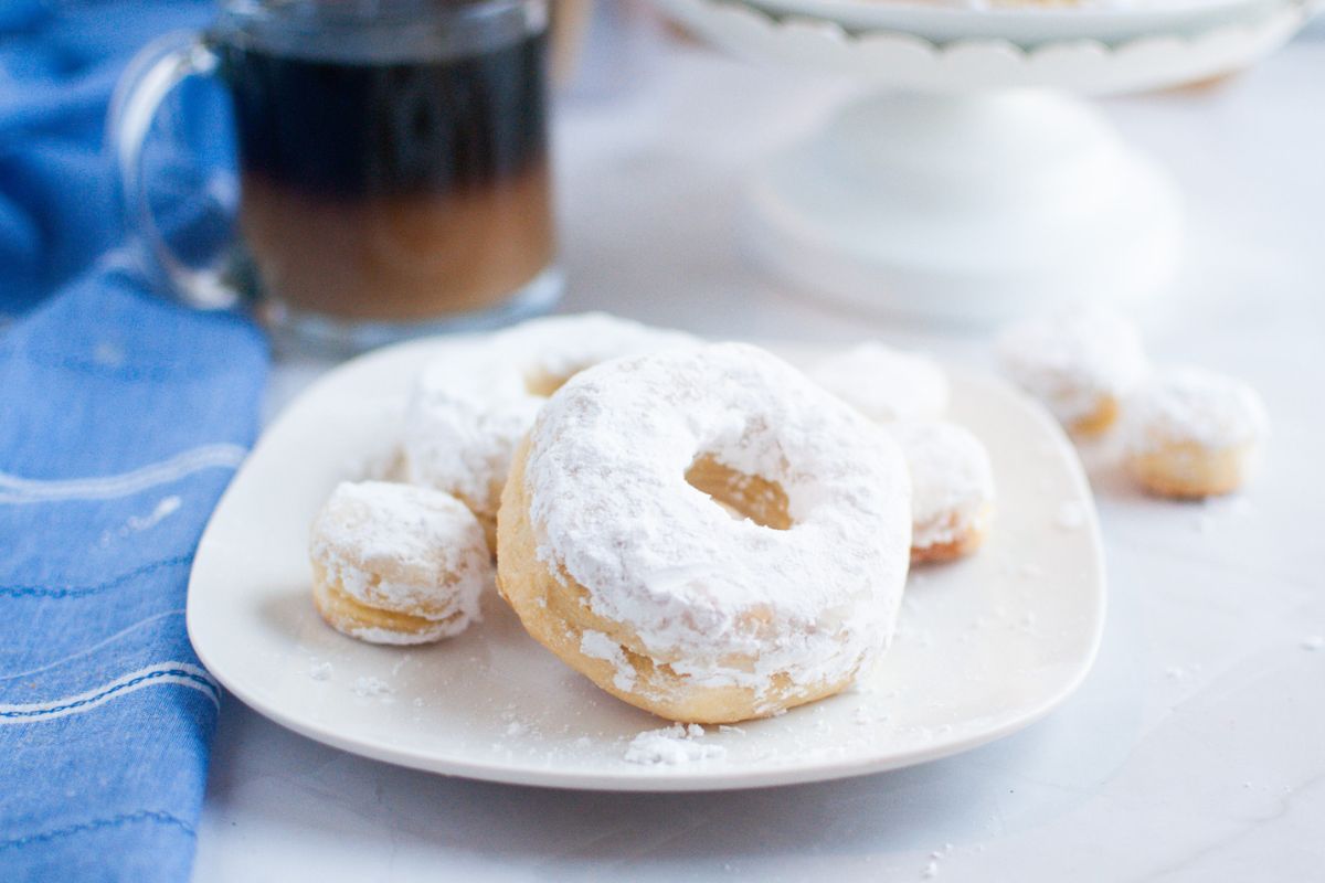 Air Fryer Biscuit Donuts with Powdered Sugar on a white serving plate