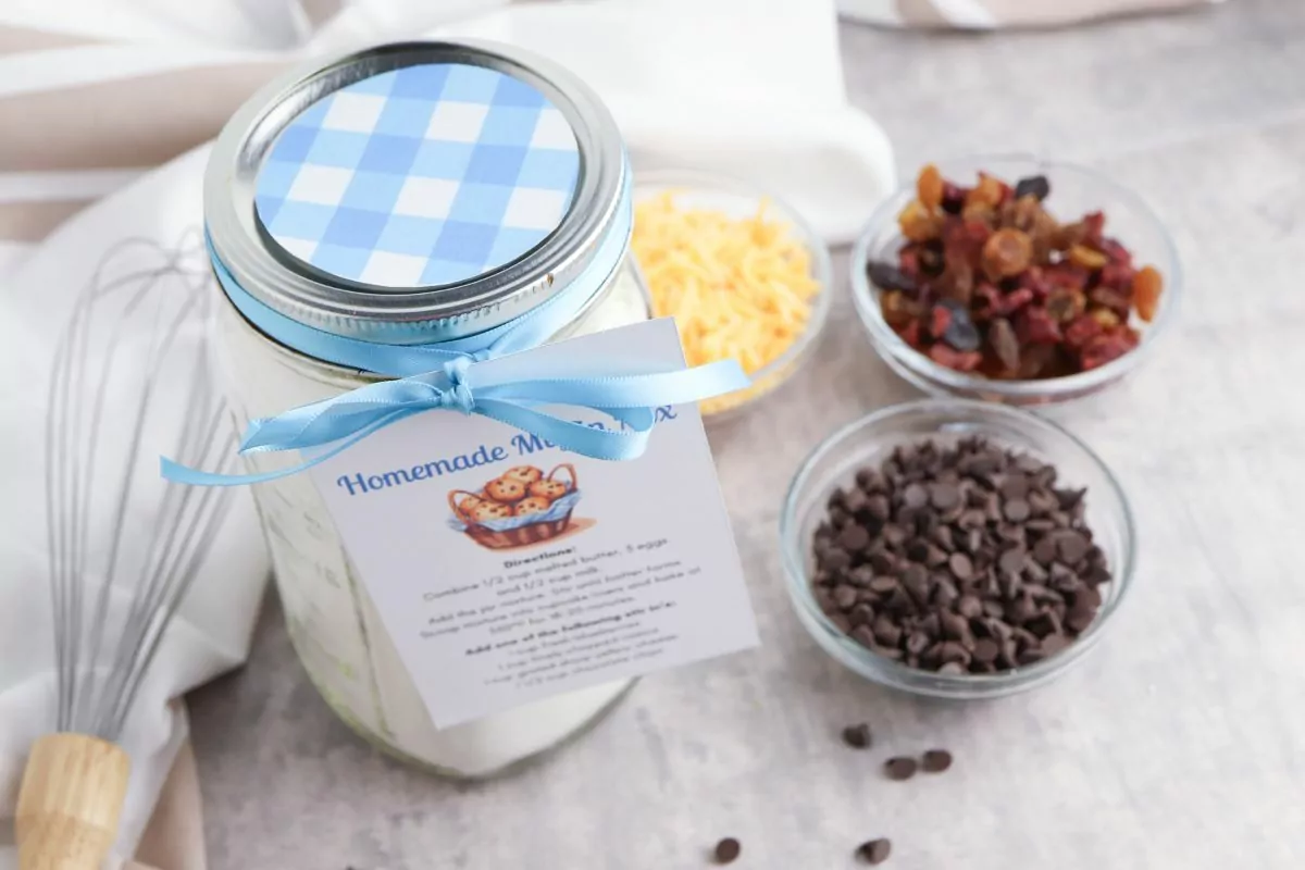 Muffin Mix in a Jar with small bowls of chocolate chips, raisins, and shredded cheese