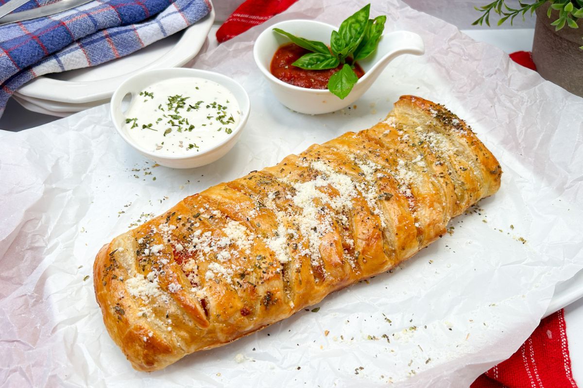 Puff Pastry Pizza Braid served with bowls of extra pizza sauce and ranch.