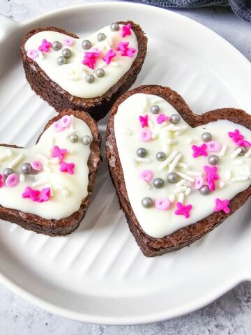 3 brownies in heart shapes on white plate.