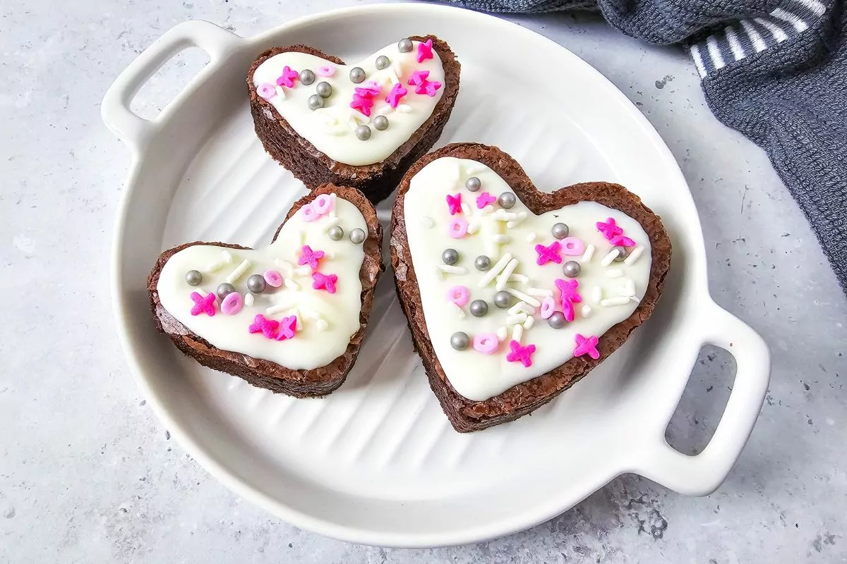 3 brownies in heart shapes on white plate.