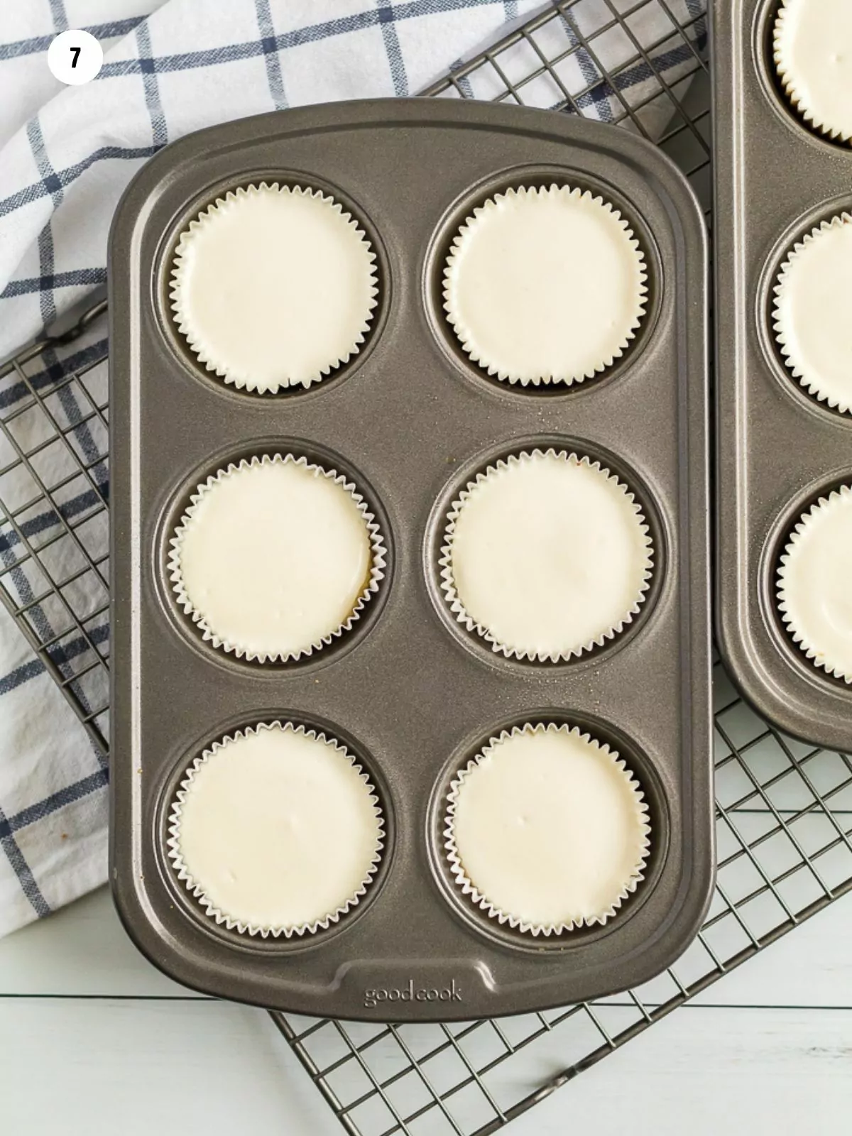 baked cheesecakes in muffin pan on top of cooling rack.