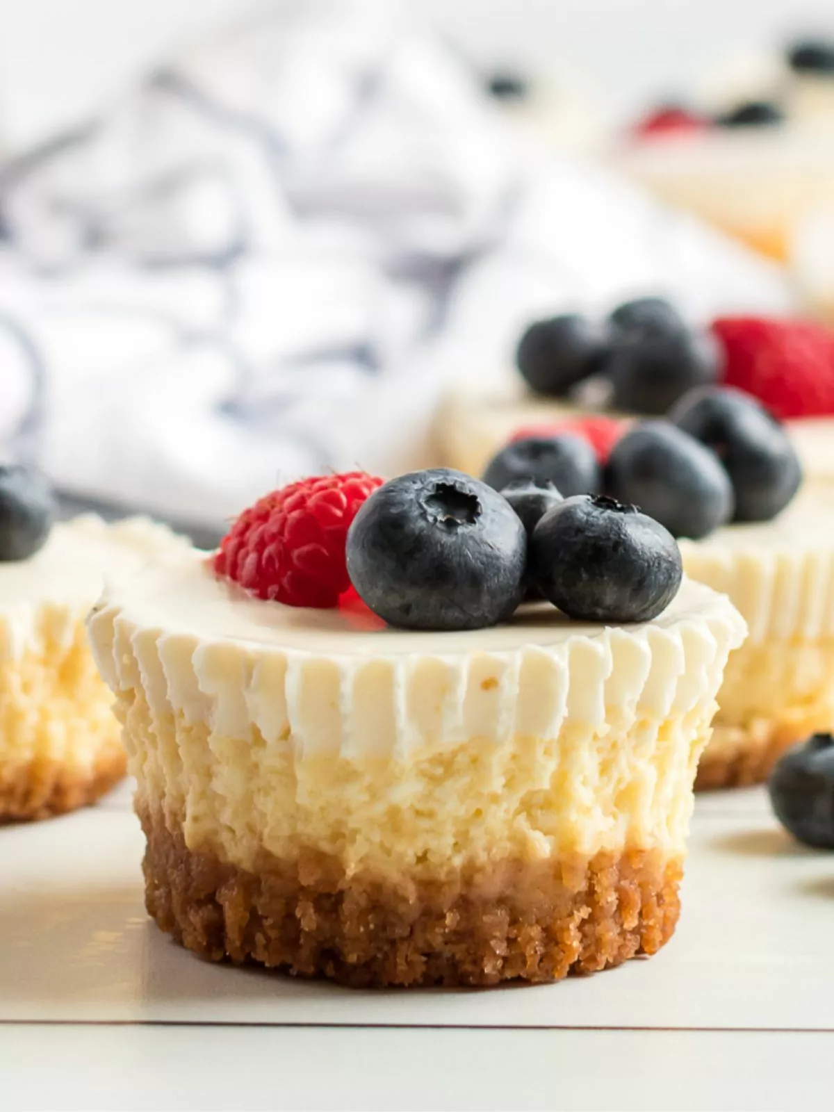 closeup of individual cheesecakes with berries.