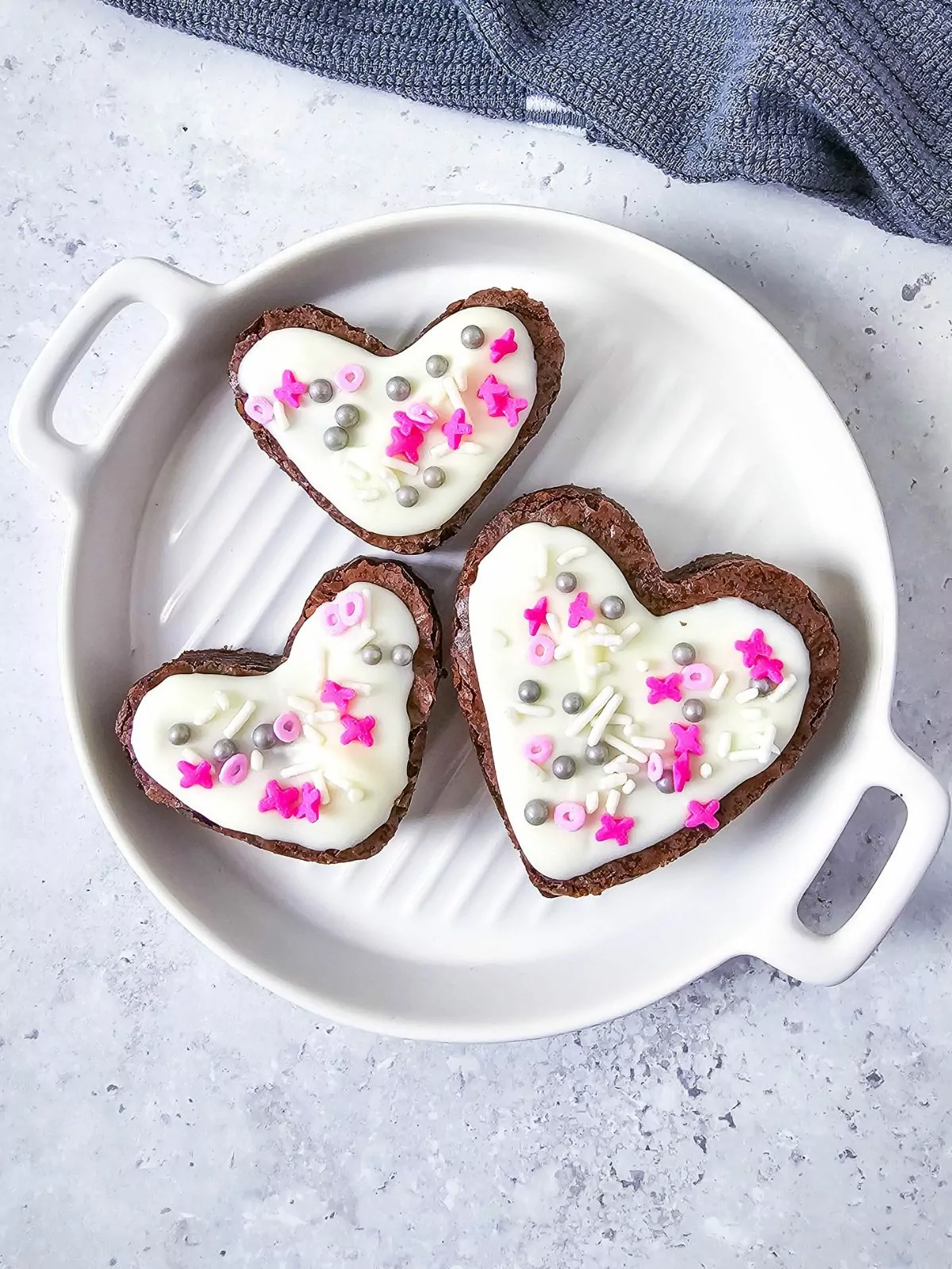 3 brownies with white chocolate icing in heart shaped.