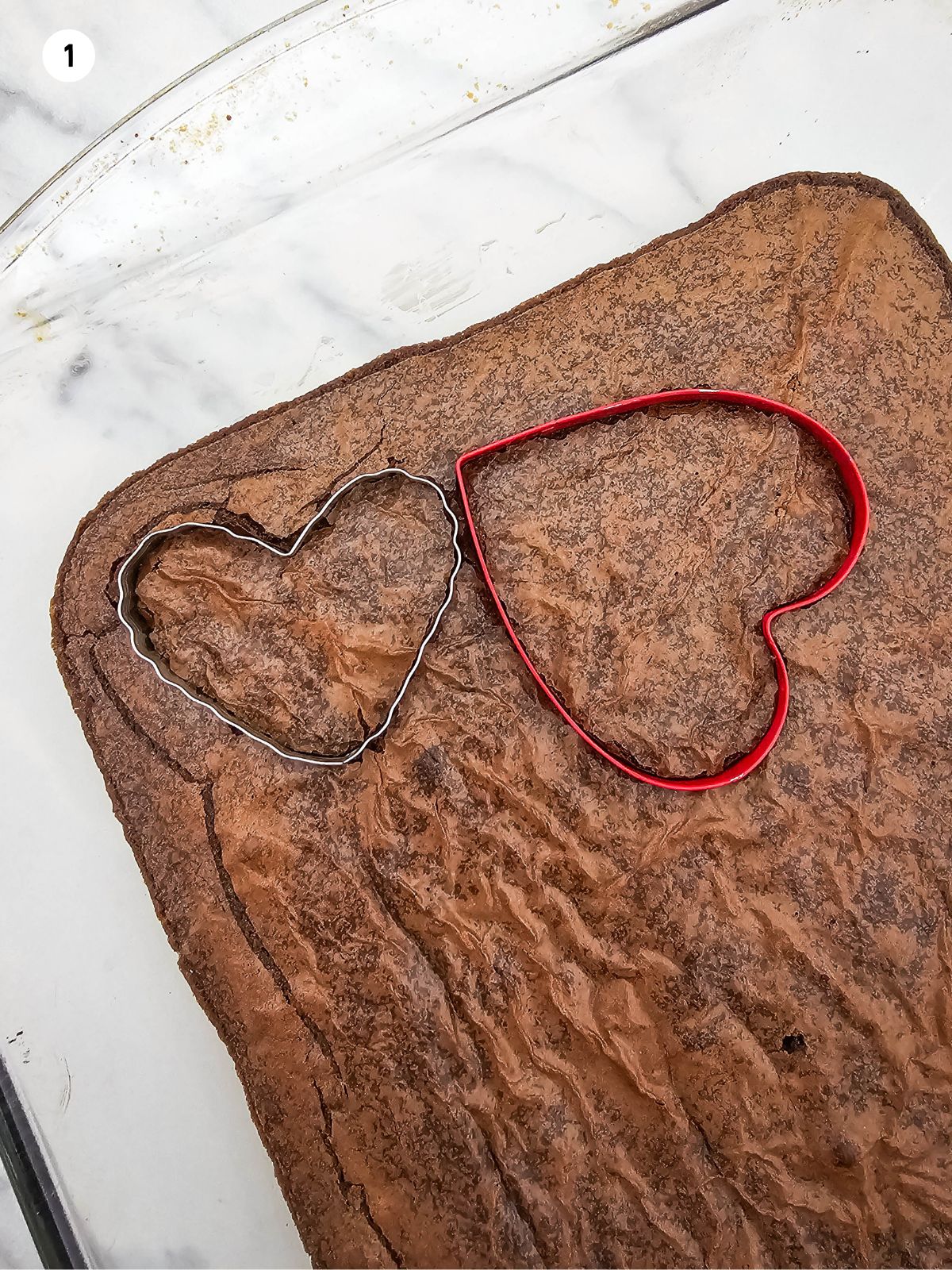 two different sized cookie cutters placed on top of baked brownies.