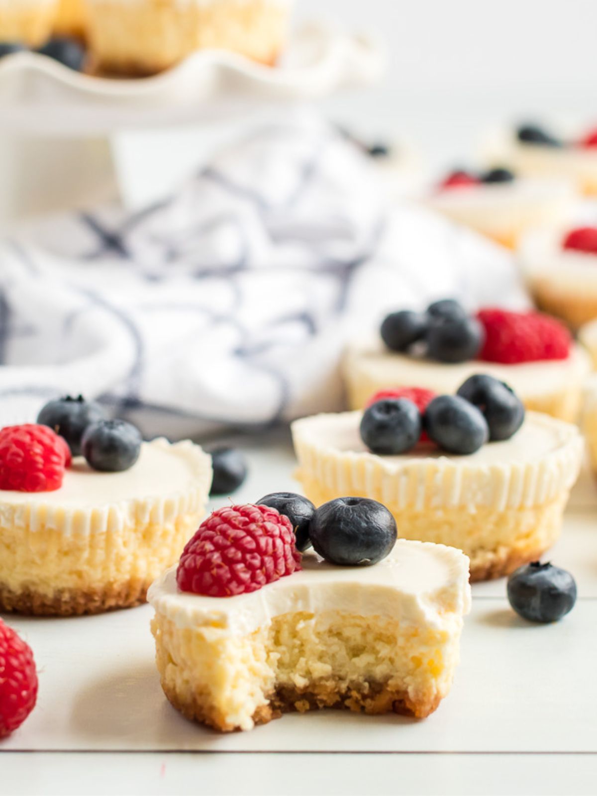 bite taken out of individual cheesecake with berries.