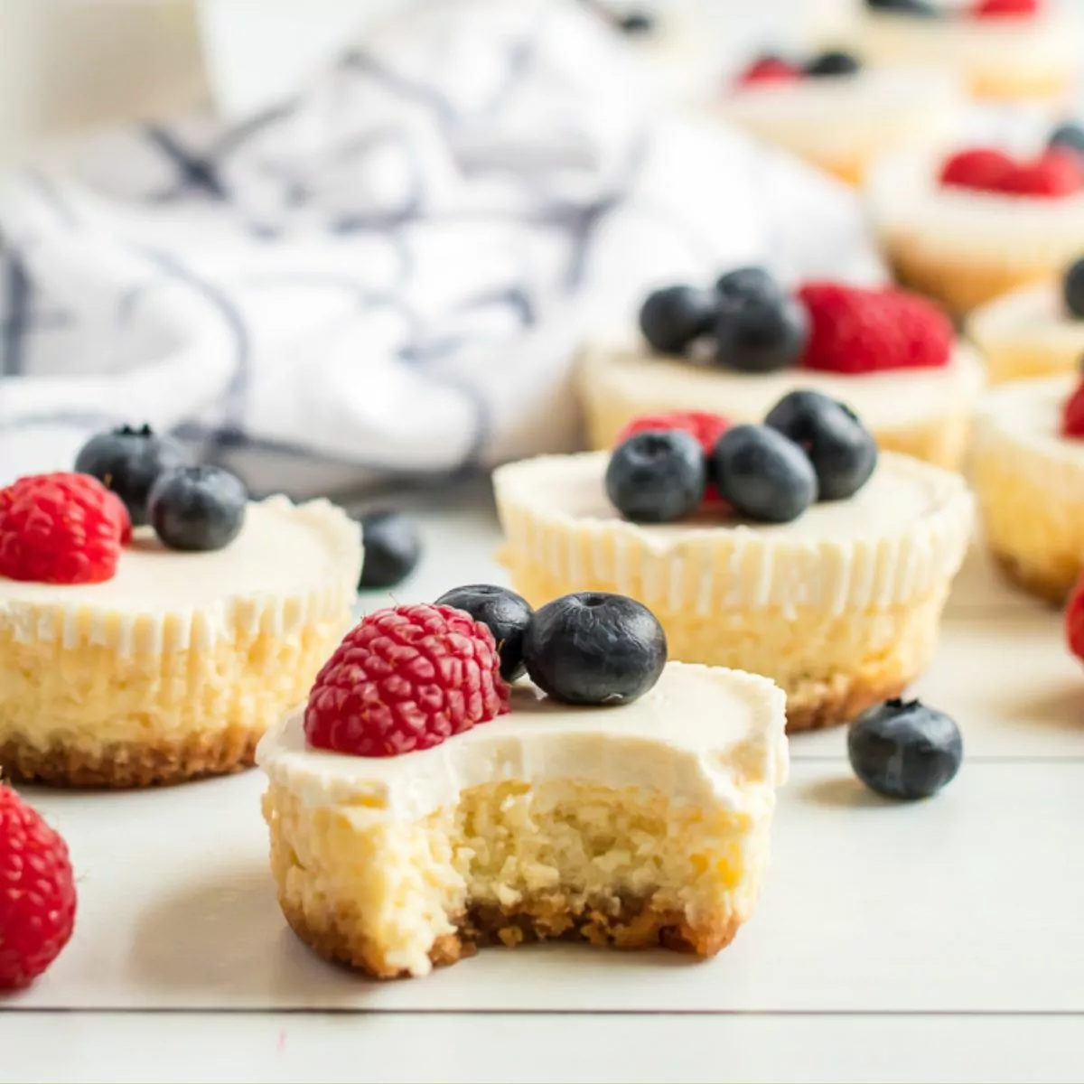 baked cheesecakes with fresh berries on cutting board.