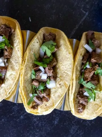 3 beef tacos with fresh cilantro and chopped onions MSN.