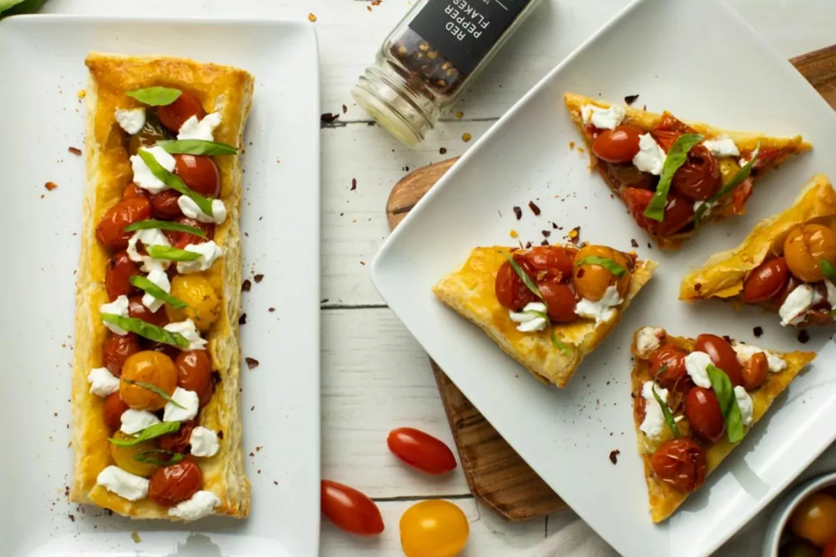 tomato puff pastry served whole and cut into triangles on white plates MSN.