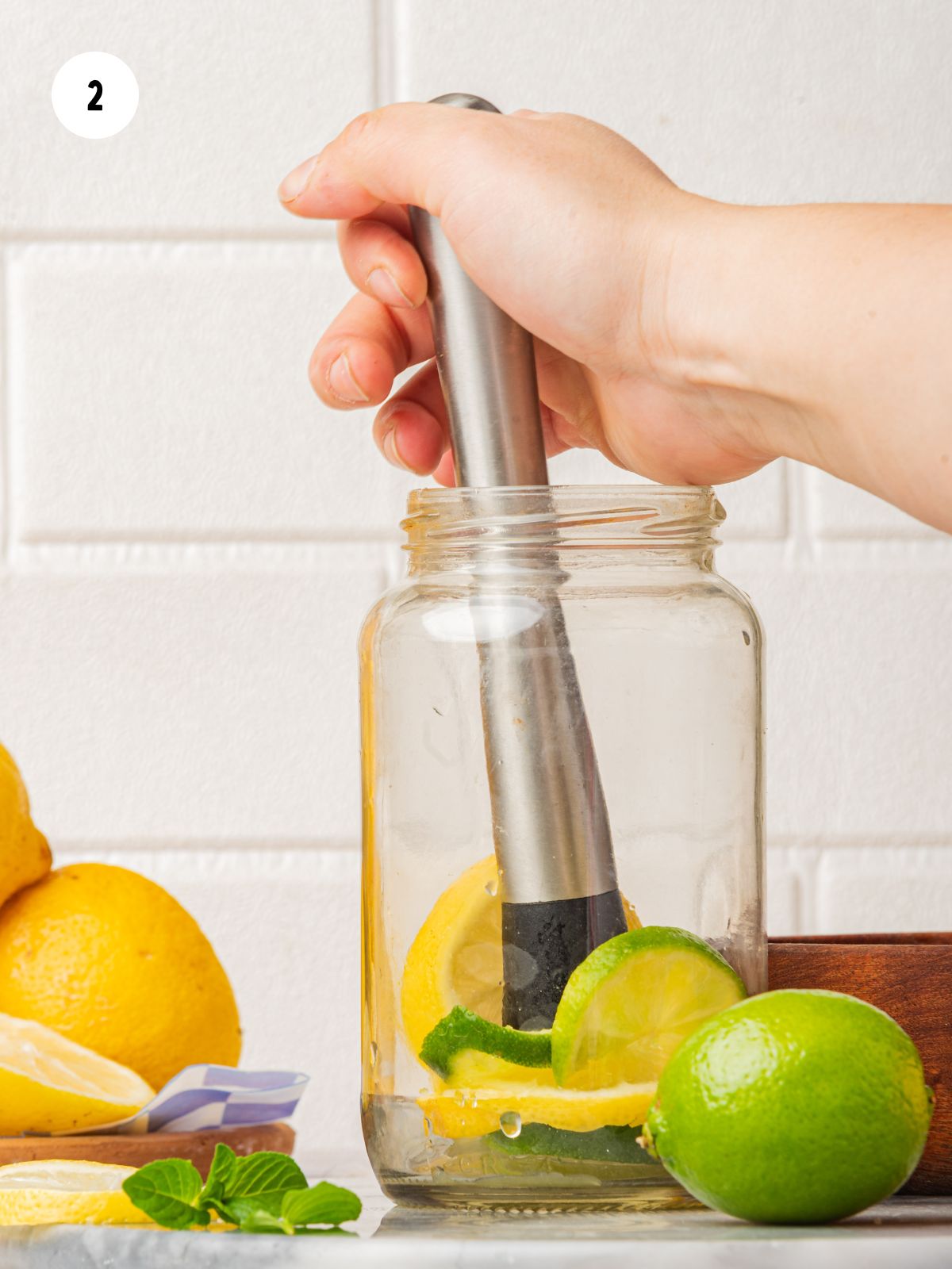 lemons and limes muddled in jar