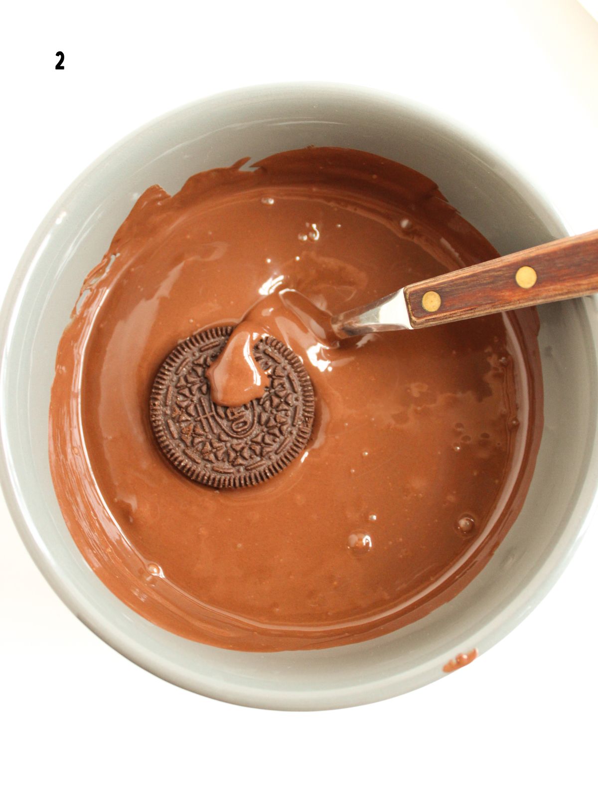 oreo dipped in melted chocolate with a fork