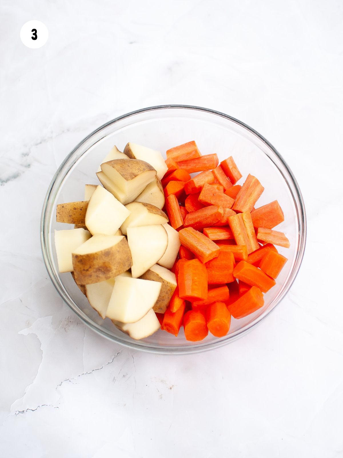 cut potatoes and carrots in a clear bowl