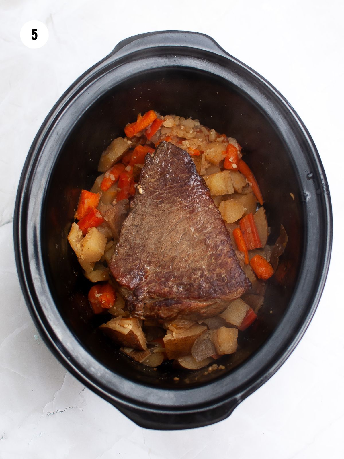 roast, potatoes, and carrots cooked in a slow cooker