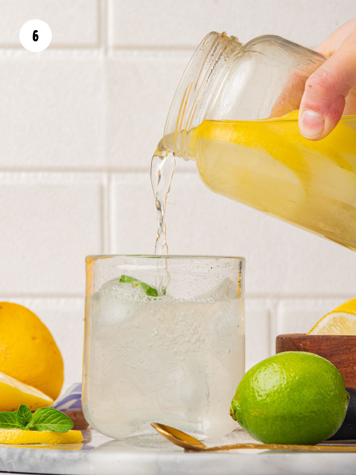 pouring lemon lime water into a glass
