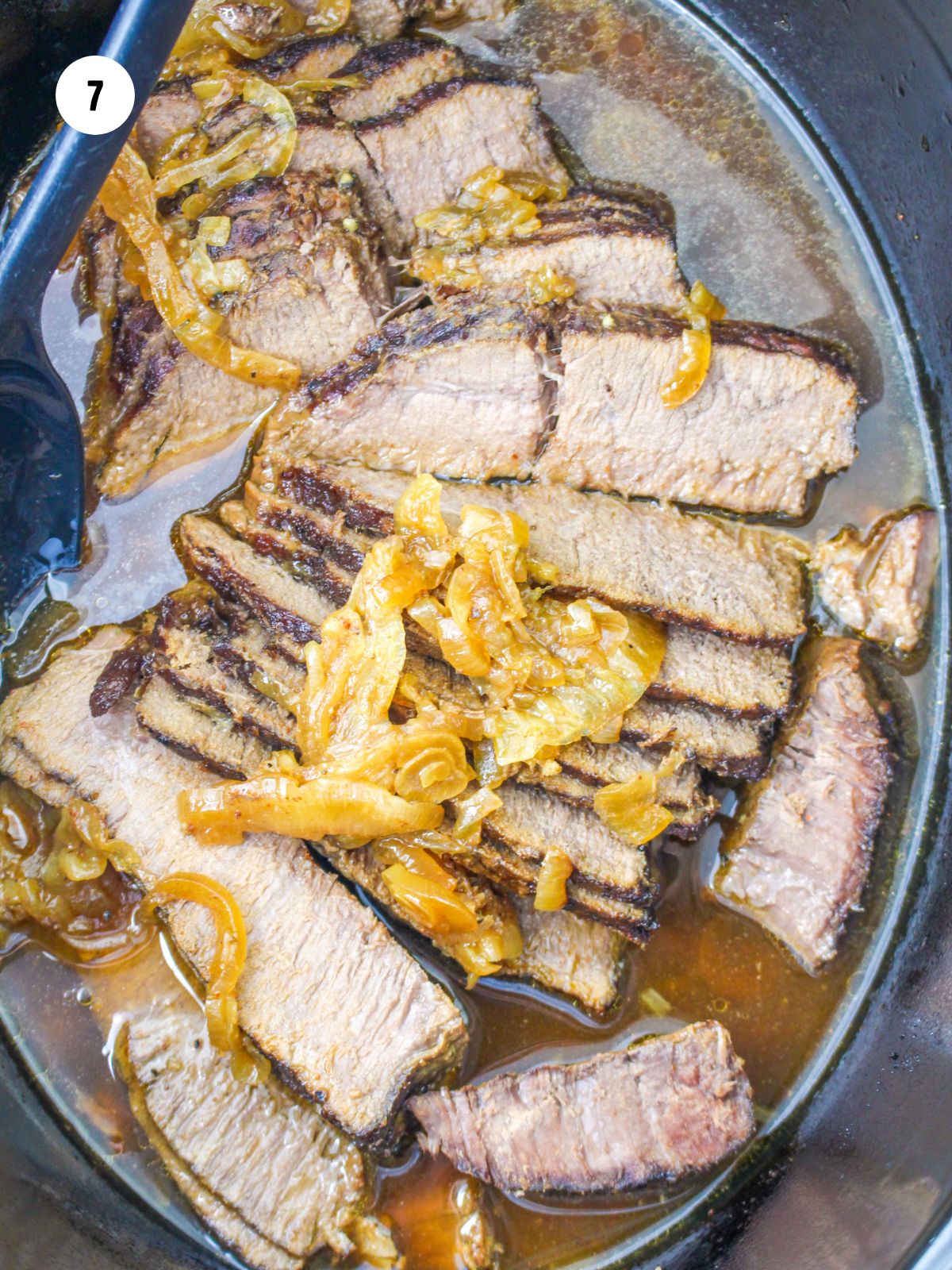 sliced flank steak and onions in the slow cooker