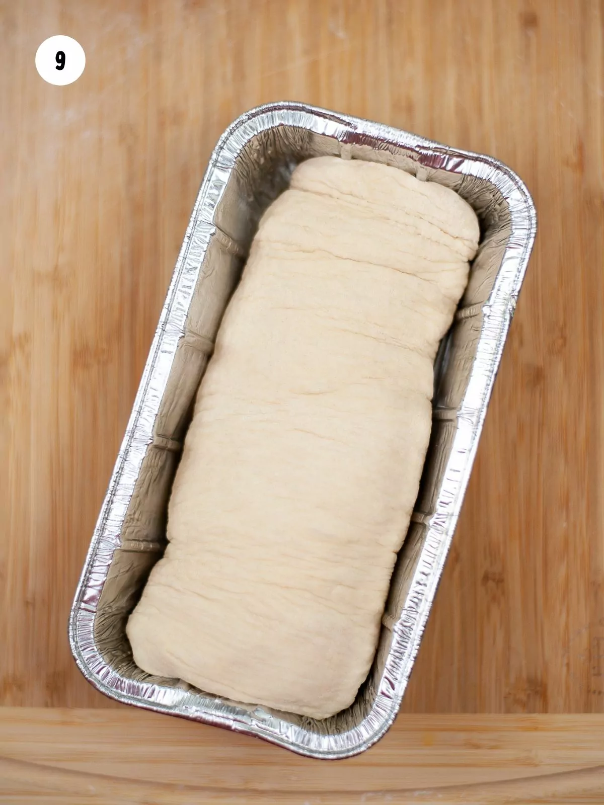 dough log in an aluminum loaf pan