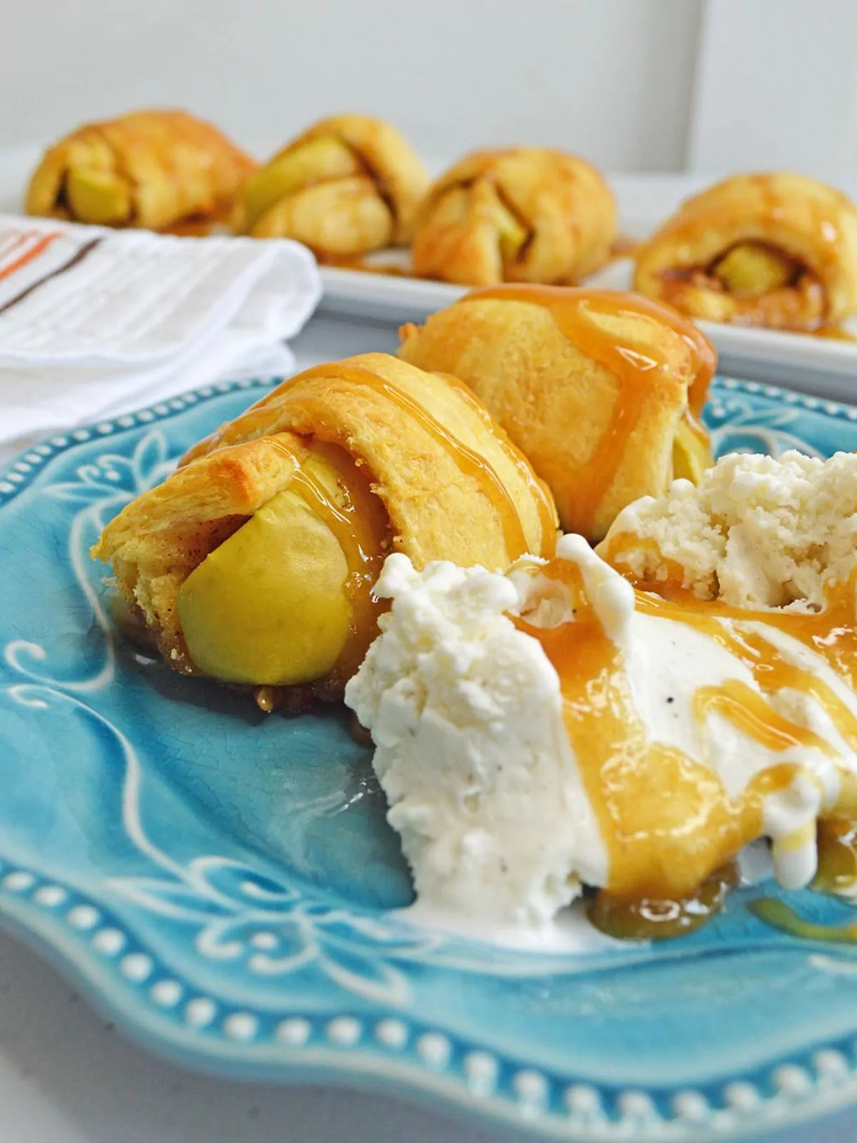 apple dumplings made with crescent rolls on plate with ice cream.