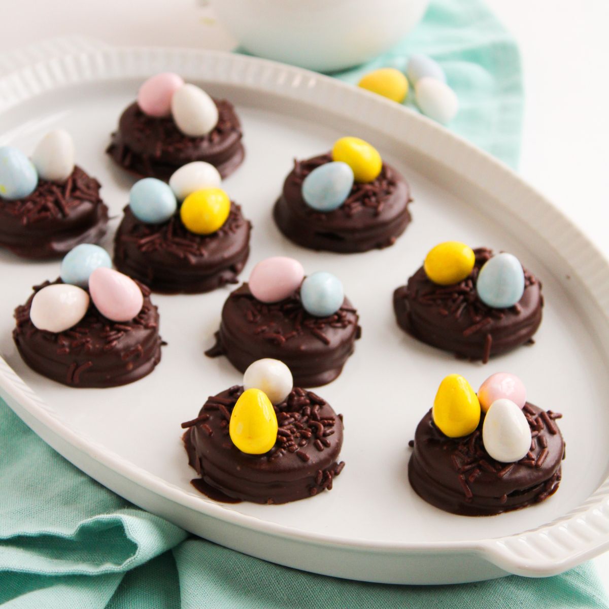 oval platter filled with chocolate covered oreos topped with chocolate sprinkles and mini chocolate eggs