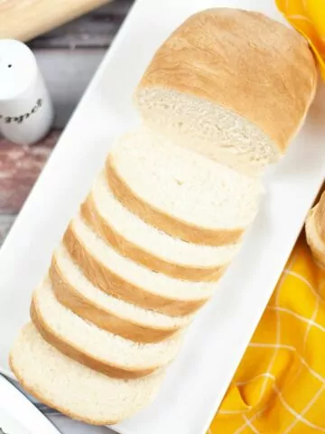 overhead view of slice Homemade White Bread on a white rectangle platter