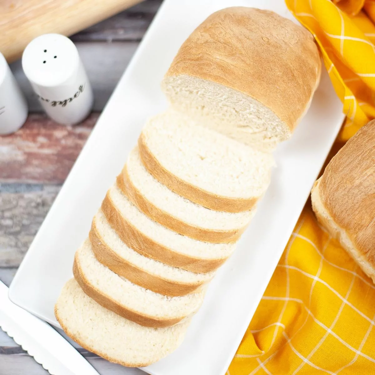 overhead view of slice Homemade White Bread on a white rectangle platter