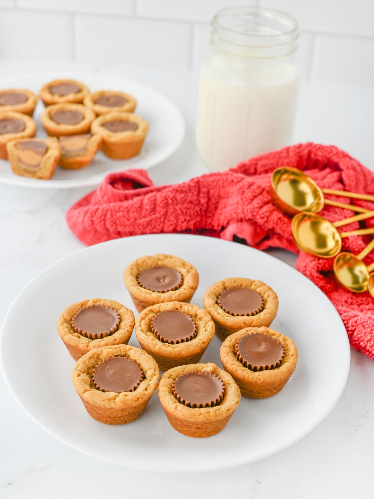 plate of Peanut Butter Cookie Cups with a cup of milk in the background