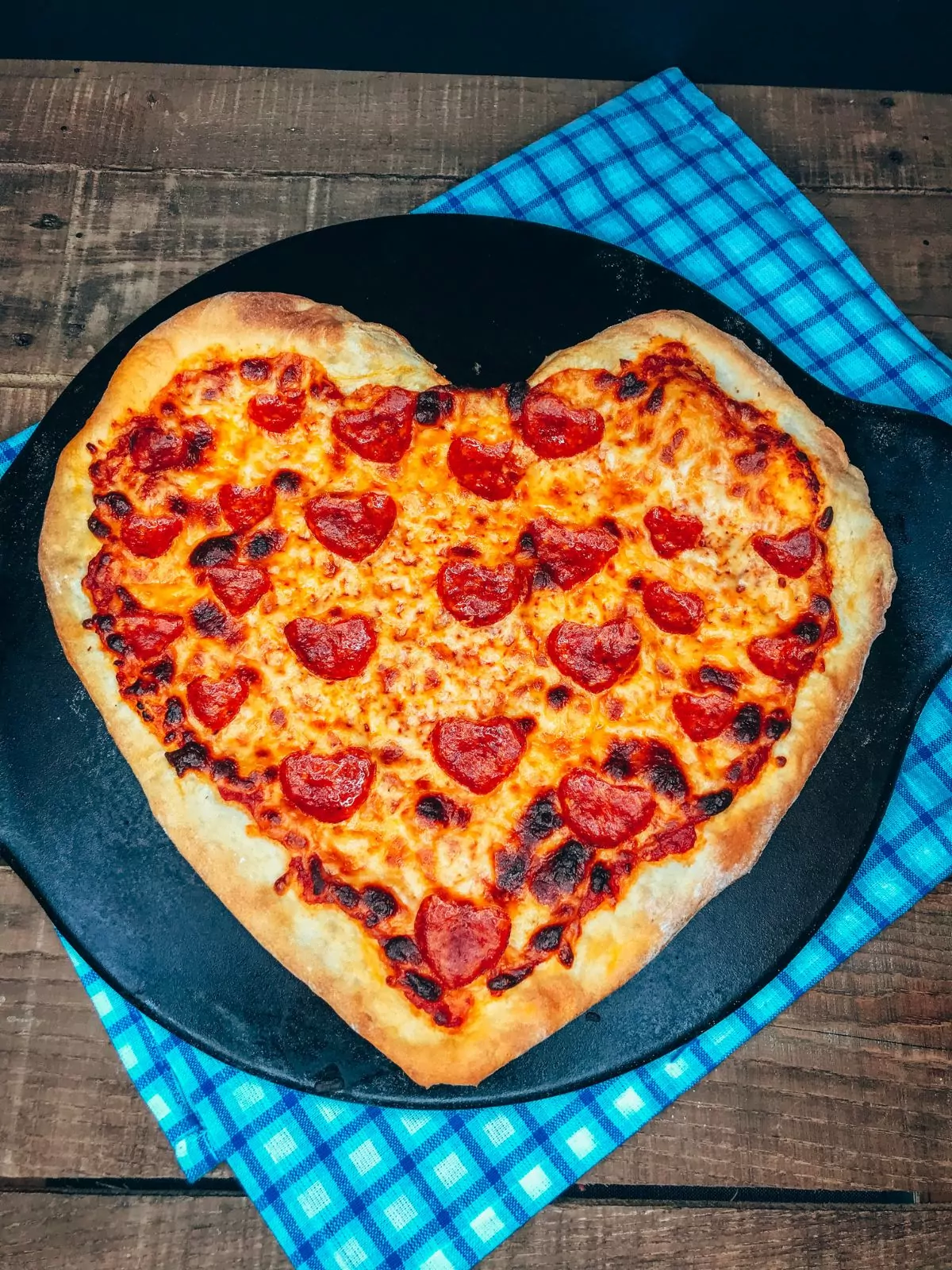 heart shaped pizza on pizza stone.