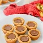 plate of Peanut Butter Cookie Cups with a cup of milk in the background