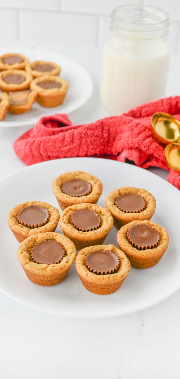 plate of Peanut Butter Cookie Cups with a cup of milk in the background