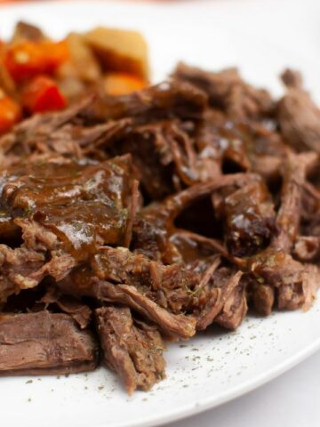 close up of slow cooked London Broil, potatoes, and carrots.