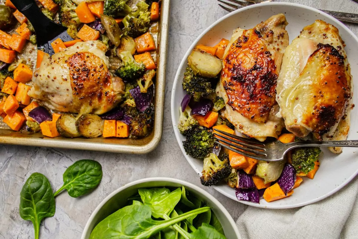 sheet pan with chicken thighs and vegetables on the left and the dish served on plate with a fork on the right