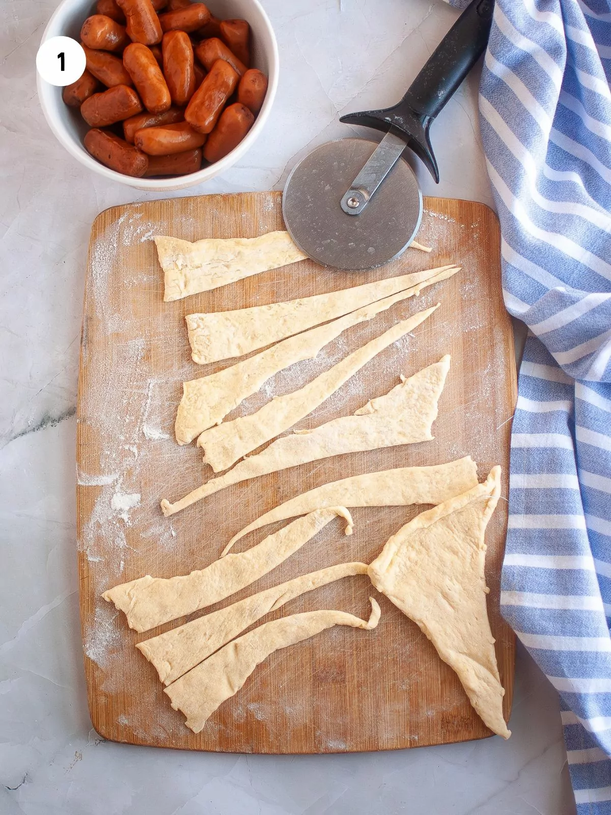 crescent roll dough cut into thin triangles of dough with a pizza cutter