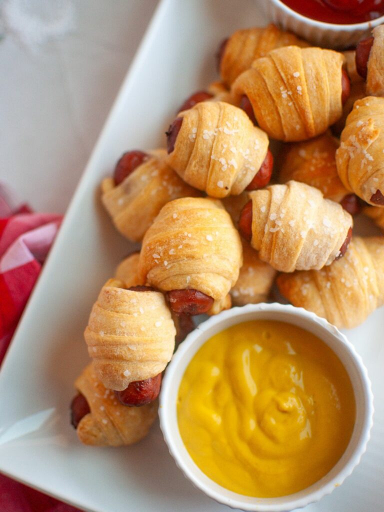 air fried sausages wrapped in crescent dough and a ramekin of mustard
