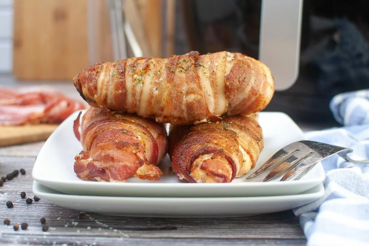 bacon wrapped chicken on white plates. msn.