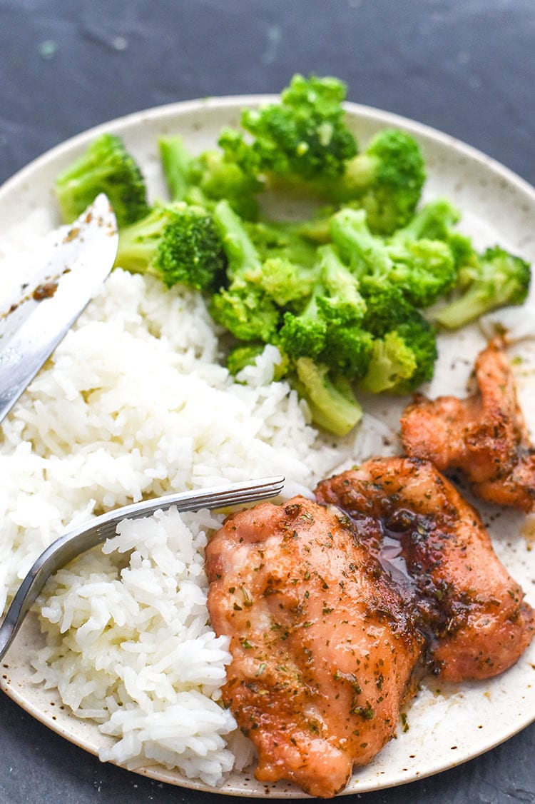 baked chicken in a plate with rice and broccoli