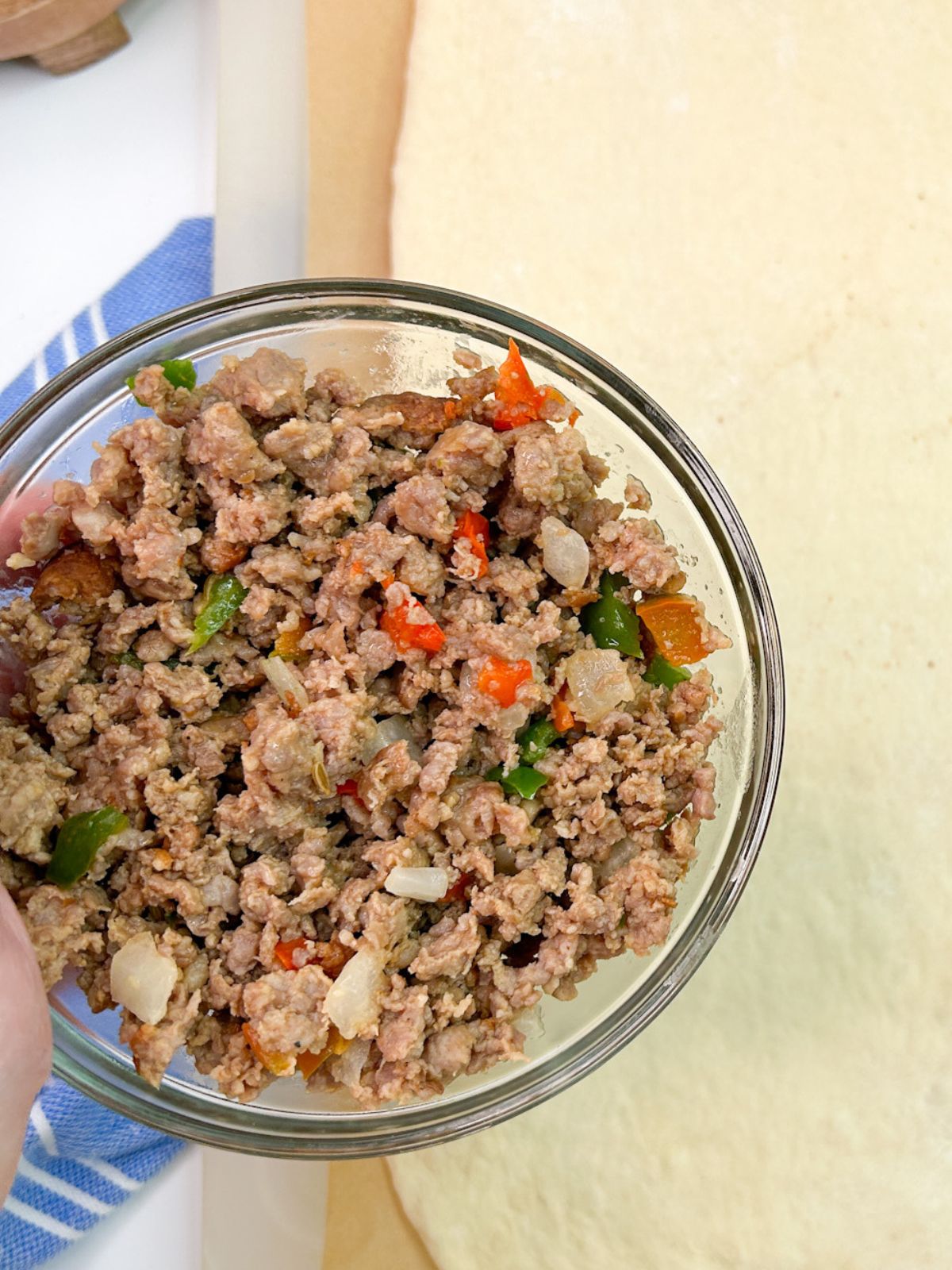 bowl of cooked ground Italian sausage with peppers and onions.